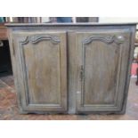 18th century oak side cupboard enclosed by a pair of panelled doors, with additional carved