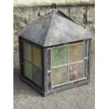 An Arts & Crafts style hanging porch lantern, the painted steel frame enclosing coloured leaded
