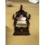 A 19th century continental wall mirror probably Italian, principally in walnut, the shaped mirror