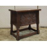 An old English oak box stool with rising lid, the front elevation with geometric carved detail