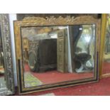 A contemporary wall mirror of rectangular form with bevelled edge plate within a ebonised and gilt