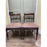 A pair of Regency mahogany side chairs, with carved and scrolled splats, upholstered seats on fluted
