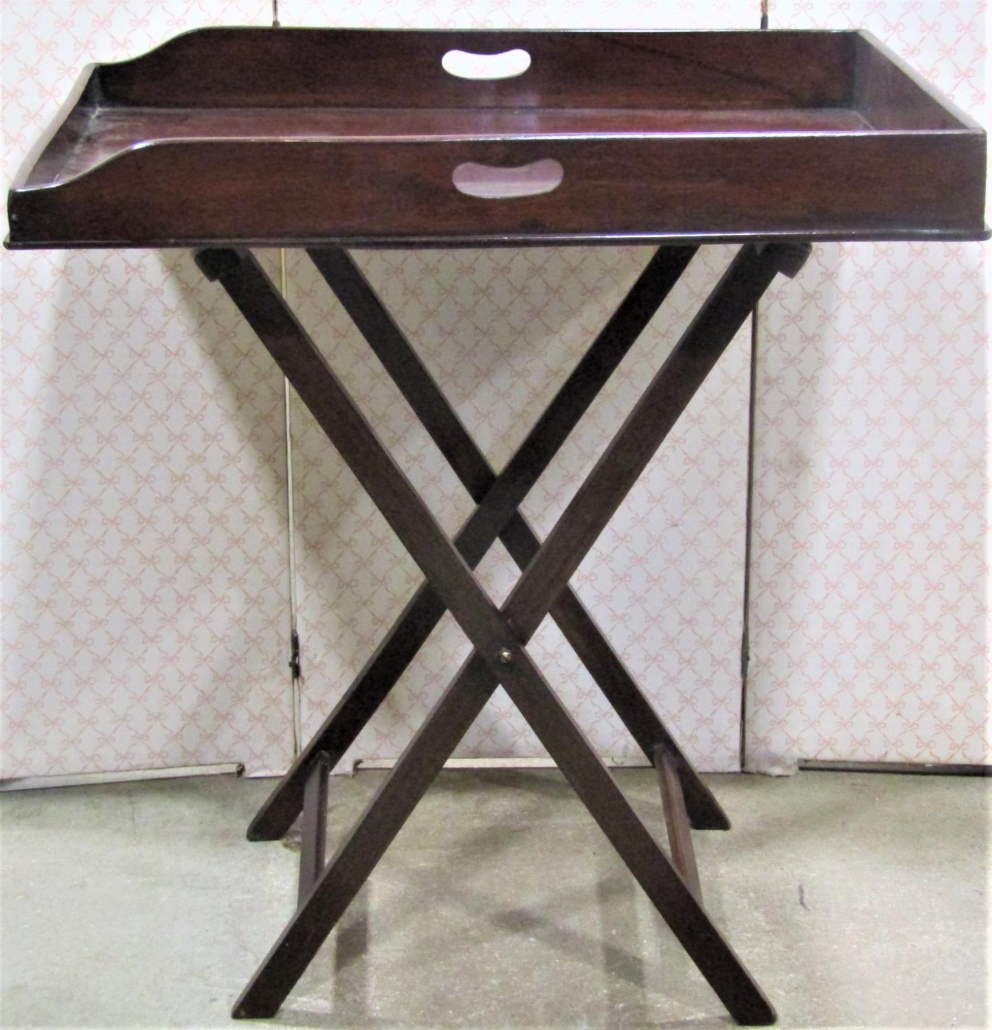 A butlers tray and stand of usual form, the tray with shaped outline raised on a folding framework