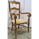 A Beech wood ladder back elbow chair with rush seat on shaped supports, a further vintage armchair
