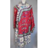 Early 20th century Chinese robe in red ground silk embroidered with moths, floral sprays, storks and