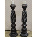 A pair of turned wood candle stands with spiral column supports, 72cm high