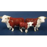 A family of Beswick Hereford cattle comprising a bull, cow and a calf (3)