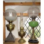 Three antique oil lamps to include a green embossed milk glass example upon a Corinthian column