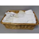 Basket containing good quality white table linen, including table cloths with crochet edge and
