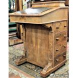 A Victorian walnut and figured walnut veneered davenport with inlaid detail and fitted with the