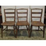 A set of three 19th century Windsor elm and fruitwood bar back kitchen chairs with turned rails