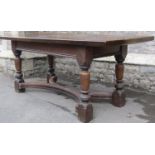 An old English style oak refectory table, the heavy planked top raised on four turned supports