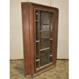 A Georgian pine hanging corner cupboard with stripped finish and glazed panel door, 110cm high