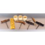 A collection of five various cork screws with turned wood and antler handles, together with a set of