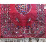 Mashad type rug with central floral blue bouquet upon a washed red ground, 230 x 170cm