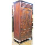 A mid-19th century continental mahogany side cupboard enclosed by a central cupboard with frieze