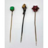 Three antique gem set stick pins to include an eagle claw example set with a citrine, a flat cut