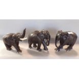 Set of three antique carved ebony figures of elephants with ivory detail, 16cm high approx (3)
