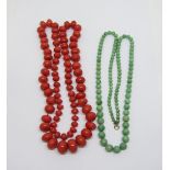 Two graduated bead necklaces; a coral example and a possibly jade example with 9ct clasp (2)