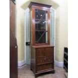 An antique mahogany side cabinet, the lower section enclosed by a pair of panelled doors and two