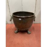 A good 19th century riveted copper cauldron, 50cm diameter, raised on four brass lions paw supports,