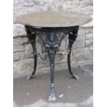 A vintage cast iron Britannia head pub table of circular form with swept and pierced supports united