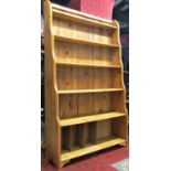 A stripped pine freestanding waterfall style bookcase with graduated open shelves, 112 cm wide x