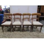 A set of four Victorian mahogany dining chairs with curved bar backs over drop in upholstered