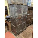 A rustic 18th century oak two sectional cupboard, enclosed by two pairs of panelled doors, with