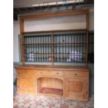 A large vintage stripped pine farmhouse kitchen dresser, the base partially enclosed by a pair or