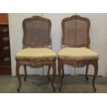 A pair of late 19th century salon chairs with later upholstered cane panelled seats,cane backs and