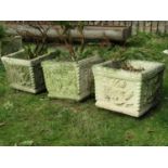 A set of three reclaimed garden planters of square form with foliate and gadroon detail (planted),