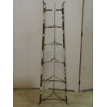 A vintage floorstanding iron strap work saucepan stand on six graduated tiers, 125 cm high