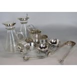 A collection of silver comprising four various silver napkin rings, pair of table salts on ball