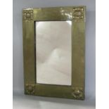 Arts and crafts brass rectangular wall mirror in the manner of Liberty, fitted with four square