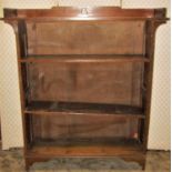 An arts and crafts style open oak bookcase with three quarter gallery, fitted with three shelves,