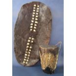 Tribal interest - hide covered drum, 27 cm high, together with a further hide shield 79 cm long (2)