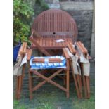 A contemporary folding hardwood garden terrace table of circular form with slatted top, together