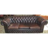 A traditional three seat brown leather upholstered Chesterfield sofa with button finish and loose