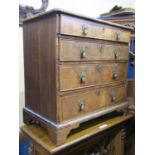A small Georgian walnut chest of four long graduated drawers, with cross banded detail, quarter