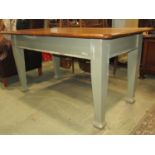 An early 20th century kitchen table, the polished oak top raised on a painted framework, 180cm x