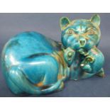 An unusual oriental turquoise glazed model of a fierce cat with a rat in its jaws (af), 28 cm long