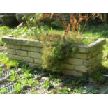 A reclaimed garden planter of rectangular form with mock stone wall façade (planted) 105cm long x