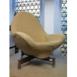 A mid 20th century swivel egg type chair raised on a x framed teak base with turned supports