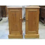 A pair of polished pine bedside cupboards