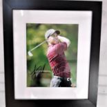 A framed signed picture of Tiger Woods with a certificate of authenticity issued by Sportizus Ltd,