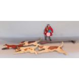 A wooden cut out scene of four hounds chasing a fox together with a further gentleman doll in the