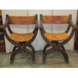 A pair of continental X framed chairs with hide upholstered seats and backs, repeating carved detail