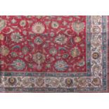 Large Persian country house carpet, with various scrolled foliage upon a red ground, 350 x 290cm