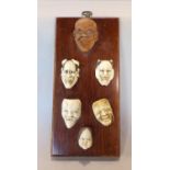 Unusual collection of Chinese ivory masks together with a boxwood example fitted to an oak panel,